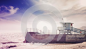 Vintage toned picture of lifeguard tower at sunset, California.