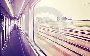 Vintage toned train window with blurred rails outside.