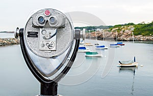 Vintage tower viewer overlooking a small harbor with sailboats