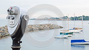 Vintage tower viewer overlooking a small harbor with sailboats