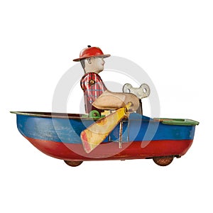 Vintage toy rowing boat with little rower isolated on white