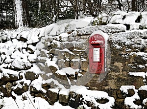 Vintage traditional red British post box in the snow