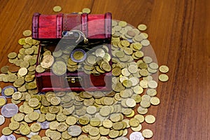 Vintage treasure chest full of golden coins on wooden background