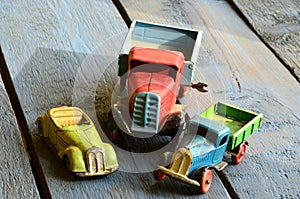 Vintage trucks (lorries) toys and covertible toy car on blue wooden background