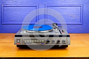 Vintage turntable vinyl record player with blue vinyl