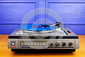 Vintage turntable vinyl record player with blue vinyl