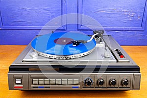 Vintage turntable vinyl record player with blue vinyl