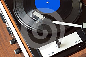 Vintage turntable with vinyl record top view closeup