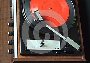 Vintage turntable with vinyl record top view closeup