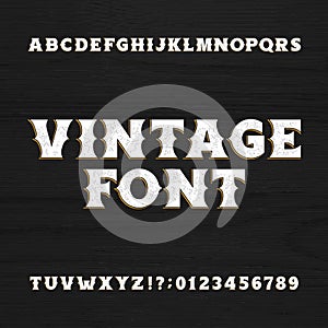 Vintage typeface. Retro distressed alphabet font on a wooden background.