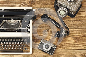 Vintage typewriter,camera and an old telephone on wooden table a