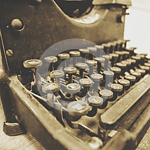 Vintage typewriter close up in sepia tone with old fashioned keys