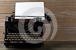 Vintage typewriter with empty, blank sheet of paper on wood table