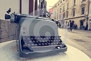 Vintage typewriter at the entrance to boutique on a tourist packed street.