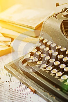 Vintage typewriter, old books on table
