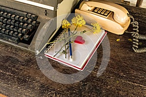 Vintage typewriter , old telephone , dry chrysanthemum flower and white paper note old wooden touch-up in still life concept