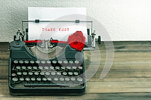 Vintage typewriter with paper page and rose flower