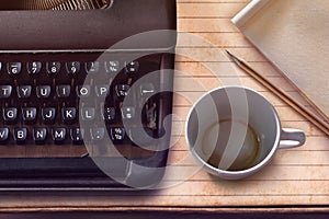 Vintage typewriter, pencil, paper and empty coffee cup