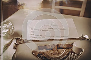 A vintage typewriter is placed on a table, with a sheet of paper inserted