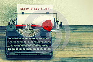 Vintage typewriter with red rose flower. Happy Womens Day photo