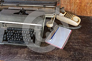 Vintage typewriter ,white  book,  ,pencil and old telephone on old wooden touch-up in still life concept