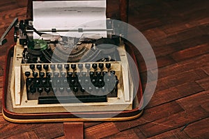 vintage typewriter with white paper stands on the floor indoors top view