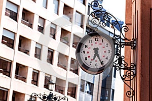 Vintage urban exterior clock with wrought iron patterned decoration