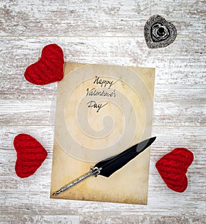 Vintage Valentine`s Day card with red cuddle hearts ink and quill - top view