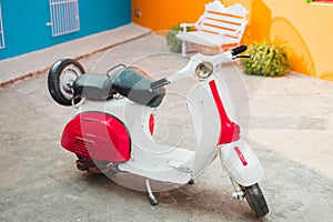 Vintage Vespa scooter parked in front of a home
