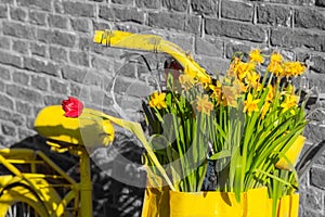 Yellow bicycle with flowers on brick wall background