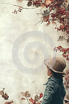 Vintage Victorian style portrait child surrounded by leaves and sharrow berries photo