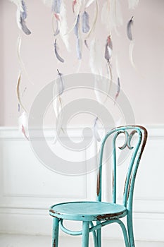 Vintage viennese chair against the wall with a bas-relief of plaster stucco. Selective focus.