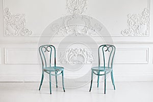 Vintage viennese chairs against the wall with a bas-relief of plaster stucco. Selective focus