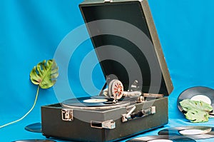Vintage vinyl record player with monsters leaf. Vinyl records on background. Retro concept