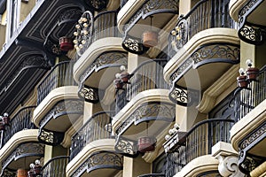 Vintage wall of a building with many balconies with wrought iron cast-iron fencing