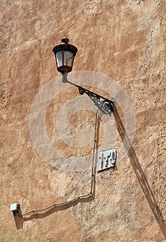 Vintage Wall-mounted Light on the Rough Wall