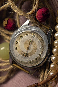 vintage warm color still life with old metal soviet vintage watch, rose flowers, pink fabric and pearl beads