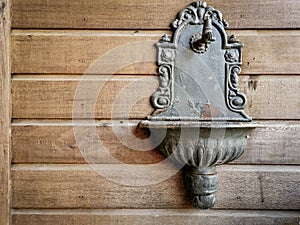 A vintage washing basin on a unpainted wooden wall