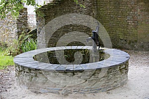 Vintage water pump at Ancient well in European village.