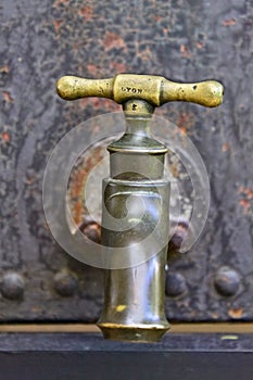 Vintage water tap on an old industrial tank.