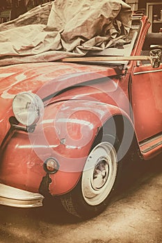 Vintage weathered classic red car in an old garage