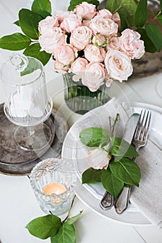 Vintage wedding table decorations with roses, candles cutlery