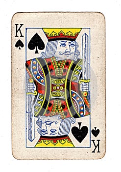 A vintage, well used king of spades playing card.