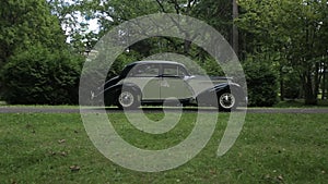 Vintage white car with black On an asphalt road in a green forest