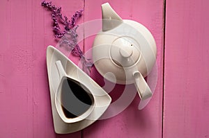 Vintage white ceramic teapot and cup of tea on a glamorous background