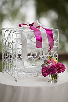 Vintage white ornated metal cage at wedding aisle with flowers i