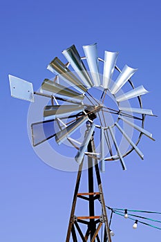 Vintage wind turbine small windmill by blue sky