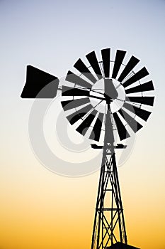 Vintage windmill silhouette against sunset.