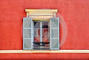 Vintage window with grey shutters in old red stucco house, Nice, France