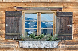 Vintage Window of old alpine house. Wooden rustic background.